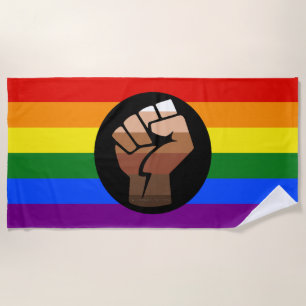 SlipperyJoe's queer people colour flag raised fist Beach Towel