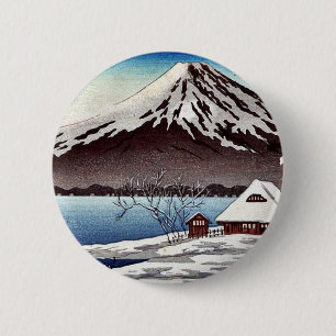Small snow covered building on the coast 6 cm round badge