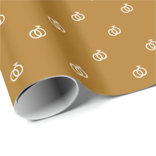 Small White Wedding Rings on Matte Gold Wrapping Paper