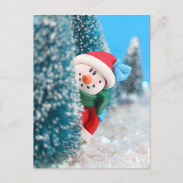 Snowman hiding or peeking from behind a tree postcard (Front)