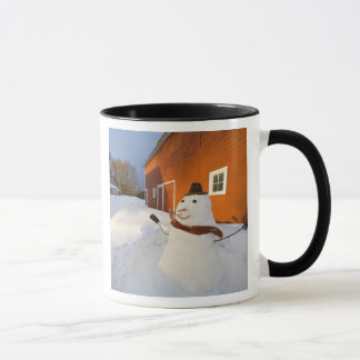 Snowman in front of red barn in Columbia Falls Mug