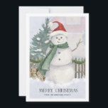Snowman in Santa Hat Pine Tree Christmas Card<br><div class="desc">Traditional Christmas card scene features a watercolor snowman with a Santa hat and green scarf. Pine trees,  firewood and a picket fence complete the holiday scene. Merry Christmas is written below in an elegant serif font. A second line of custom text lets you add your name or another sentiment.</div>