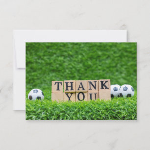 Soccer ball with word Thank you on green grass Card