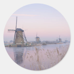 Soft sunrise light in winter over windmills classic round sticker