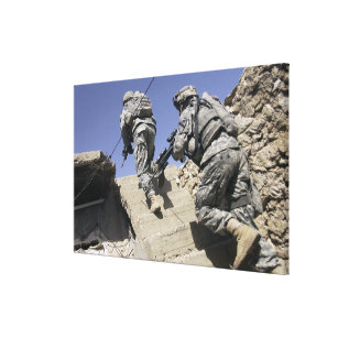Soldiers running up staircase of a building canvas print