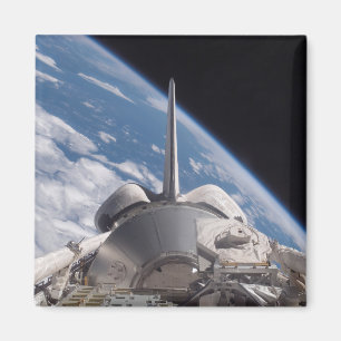 Space Shuttle Discovery backdropped by Earth Magnet