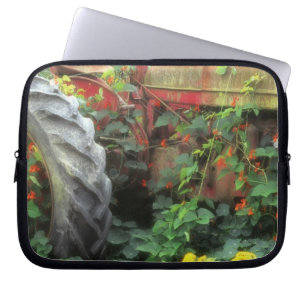 Spring flowers adorn an old tractor. laptop sleeve