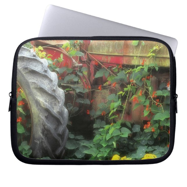 Spring flowers adorn an old tractor. laptop sleeve (Front)
