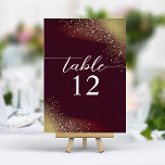 Starry Night Deep Crimson Wedding Table Number<br><div class="desc">The 'Starry Night Deep Crimson Wedding Table Number' is an elegant navigational touch to your wedding décor. The card features a rich, deep crimson background that graduates to a luminous golden hue, reminiscent of a starlit sky transitioning to dawn. A constellation of delicate golden specks scatters across the top, adding...</div>