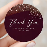 Starry Night Deep Crimson Wedding Thank You Classic Round Sticker<br><div class="desc">The 'Starry Night Deep Crimson Wedding Thank You Classic Round Sticker' is a beautiful and thoughtful way to express your gratitude to guests. The sticker features a deep crimson background that's reminiscent of the velvety night sky, crowned with a shimmering arc of golden star dust. The words "Thank You" are...</div>