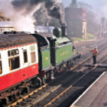 STEAM TRAINS TILE<br><div class="desc">A beautifully restored steam train and carriages of a bygone era leaving the train station and the engine driver hands over the key before being allowed to proceed along the railway. England UK.</div>