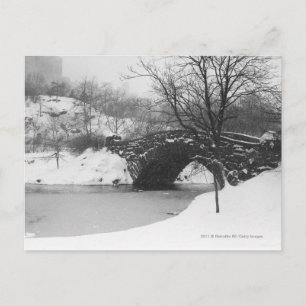 Stone bridge over snow covered river postcard