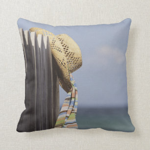 Straw Hat Hanging On Fence At Beach Cushion