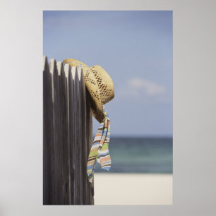 Straw Hat Hanging On Fence At Beach Poster