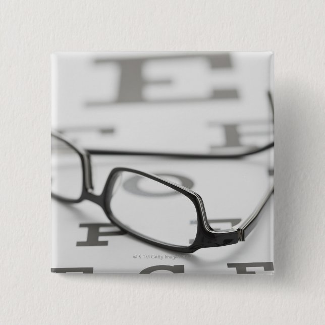 Studio shot of eyeglasses on eye chart 15 cm square badge (Front)