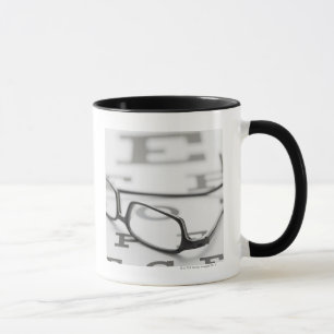 Studio shot of eyeglasses on eye chart mug