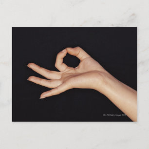 Studio shot of hand gesturing a sign postcard