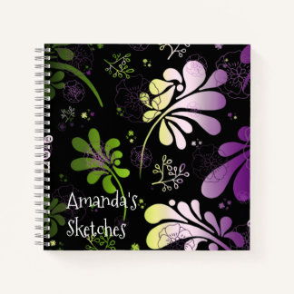 Stylised colourful leaves and flowers on black notebook