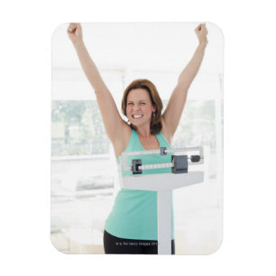 Successful weight loss. Happy woman weighing Magnet