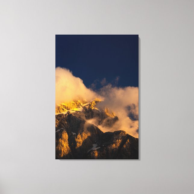 Sun lit mountains covered by clouds canvas print (Front)