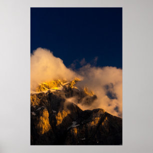 Sun lit mountains covered by clouds poster