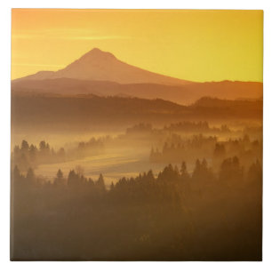 Sunrise orange colours the fog in the valley in tile