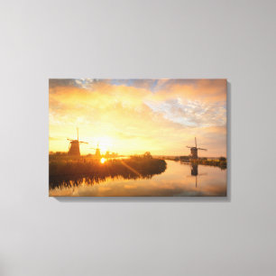 Sunrise over windmills and a river in Holland Canvas Print