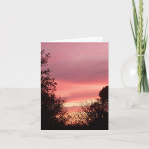 Sunrise turns the clouds red on a blank note card