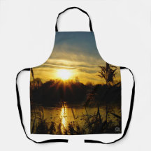 Sunset by a small lake with reed plumes.