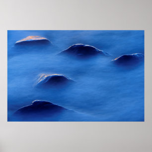 Sunset on rocks protruding through foamy water poster