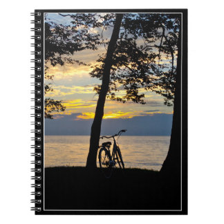 Sunset over lake with bicycle notebook