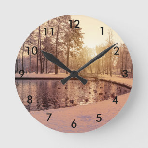 Sunset over park with small frosty lake round clock