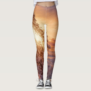 Sunset over sea and snowy pine tree leggings