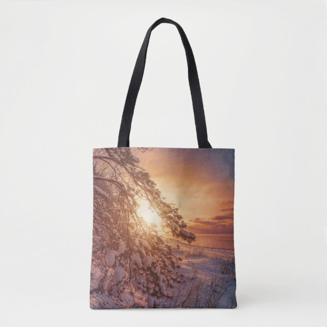 Sunset over sea and snowy pine tree tote bag (Front)