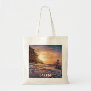 Sunset over snowy winter sea coast tote bag