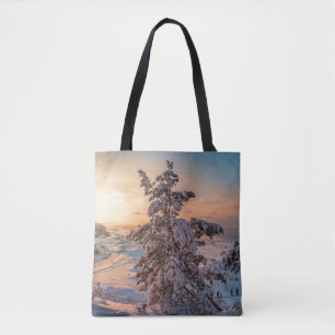 Sunset over winter snowy sea coast tote bag