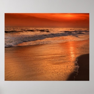 Sunset reflections off clouds and ocean shore poster