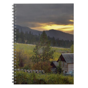 Sunset sky over vineyards and historic log cabin spiral notebook