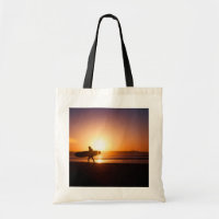 Surfer with Surfboard on Beach at Sunset