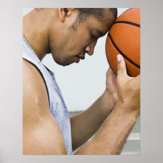 sweating man leaning forehead on basketball poster