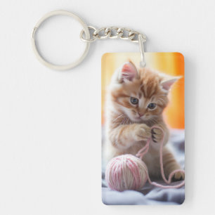Sweet orange kitten playing with yarn key ring