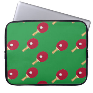 Table tennis racket and ball on green laptop sleeve