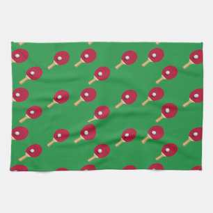 Table tennis racket and ball on green tea towel