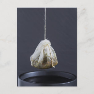 Tea bag is hung in a cup postcard
