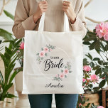 Team Bride Custom Elegant Pink Floral Gold Wedding Tote Bag<br><div class="desc">Add a touch of floral elegance to your wedding celebration! This stunning Team Bride tote bag features a beautiful double gold hoop wreath adorned with romantic pink watercolor roses and soft green foliage. It's the ideal bridesmaid gift bag, perfect for holding all the essentials for a bachelorette weekend, bridal shower,...</div>