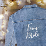 Team Bride Wedding Personalised Denim Jacket<br><div class="desc">Celebrate your bride squad with this personalised wedding denim jacket! The words 'Team Bride' are written in a trendy script font, and below you can add a custom name, wedding date, location or other text. This stylish cotton-blend jean jacket makes a lovely gift for a bachelorette party or celebration weekend!...</div>