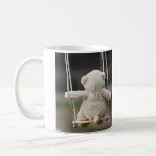 Teddy bear on a swing in motion. coffee mug