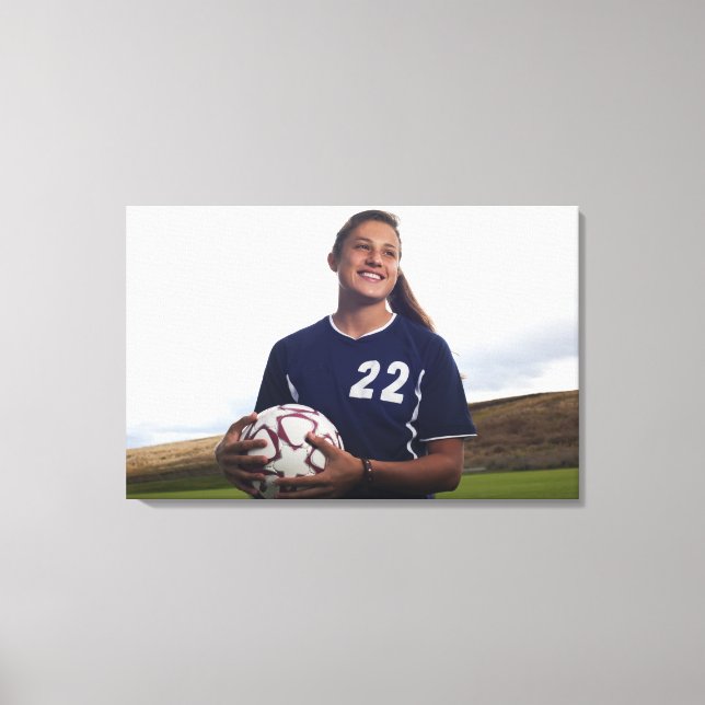 teen girl soccer player holding soccer ball canvas print (Front)