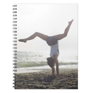 Teenage girl performs gymnastic feat, mum spiral notebook