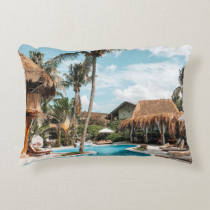 Thatch huts and houses by the pool during day decorative cushion